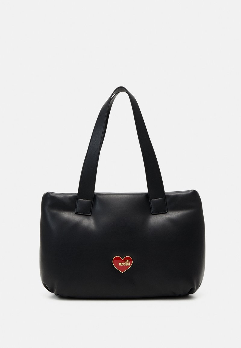 Sac fourre-tout en similicuir noir avec deux anses plates et un détail de logo en forme de cœur rouge et or à l'avant, présentant une texture lisse.