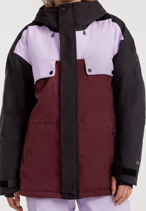 Kvinde iført en vinterjakke med farveblokke og hætte, med paneler i bordeaux, sort og lavendel, forlommer og trykknaplukninger.