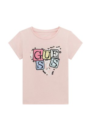 T-shirt rose clair en coton avec des manches courtes. Présente un design graphique du mot "GUESS" dans des caissons colorés et des accents ludiques.