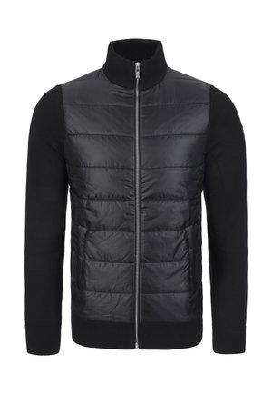 Svart hybridjacka med vadderad framsida och stickade ärmar. Har hög krage och hel dragkedja. Slät, glänsande yta fram.