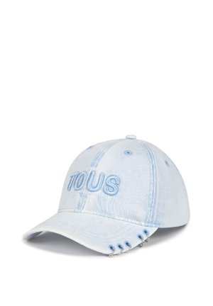 Gorra de béisbol de mezclilla azul clara con "TOUS" bordado en el frente y cinco pequeños anillos plateados unidos al borde de la visera.