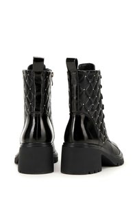 Black lace-up ankle boots with quilted texture, glossy finish, gold studs, and a block heel. Features a side zipper and pull tab.