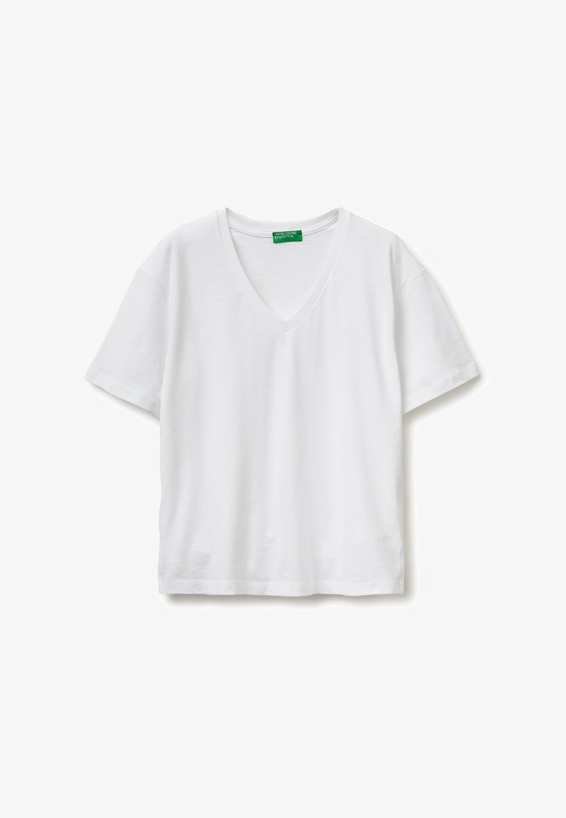Camiseta blanca de manga corta con cuello en V, extendida sobre una superficie plana, con una etiqueta verde en el cuello que muestra la marca "United Colors of Benetton".