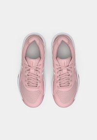 Jasnoróżowe buty sportowe z panelami z siateczki, sznurowane, z wyściełanym językiem oraz białymi akcentami na podeszwie i bokach. Widok z góry.