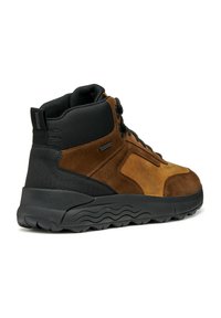 Zapato de caña alta de ante marrón y material sintético negro con una suela de goma texturizada, que presenta cordones redondos y detalles de costura reforzada.