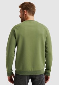 Groene sweatshirt met lange mouwen, geribbelde manchetten en zoom, voorzien van een ronde halslijn en een textuursteek langs de schouders.