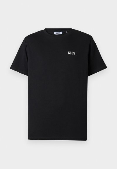 Čierne bavlnené tričko s okrúhlym výstrihom a krátkymi rukávmi. Biele logo "GCDS" je umiestnené na ľavej strane hrudníka.