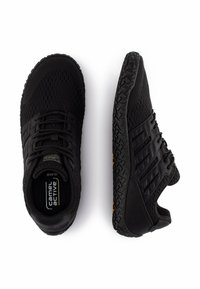 Baskets de sport noires avec une tige en mesh, une semelle en caoutchouc texturé et des lignes diagonales distinctes sur les côtés. Caractéristiques d'un design léger.