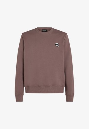 Brun sweatshirt gjord av mjukt tyg, med rund hals och ribbade muddars. Inkluderar en liten grafisk logotyp på vänster bröst.