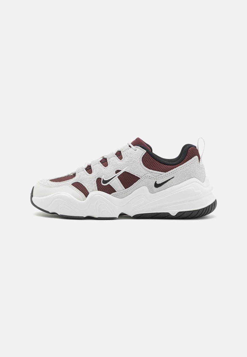 Sneaker Nike con un design a materiali misti, con suede grigio, accenti in rete bordeaux, suola bianca e suola in gomma nera.