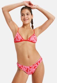 Red and pink bikini set featuring a triangle top and low-rise bottom; textured fabric with a leaf pattern and thin straps.
