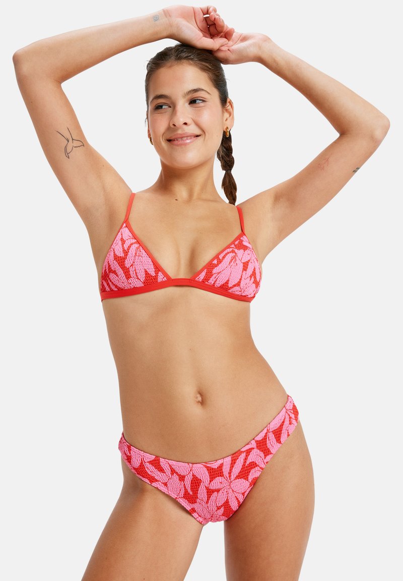 Red and pink bikini set featuring a triangle top and low-rise bottom; textured fabric with a leaf pattern and thin straps.