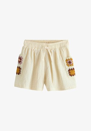 Pantaloncini in tessuto crema con vita elastica e coulisse, con due tasche applicate all'uncinetto in tonalità senape, marrone e rosa.