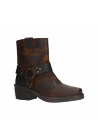 Bruine leren enkellaars met een ronde neus, een lage hak en een zwarte band met gouden metalen accenten. Gladde textuur met een lichte glans.