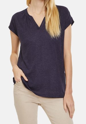 Haut à manches courtes marine avec un col en V, présentant de légères fronces le long du décolleté. Fabriqué à partir d'un tissu doux et texturé.