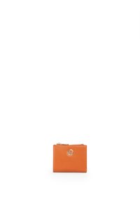 Portafoglio in pelle arancione dalla forma quadrata, con chiusura a zip e un'emblema circolare al centro. Texture liscia e design minimalista.