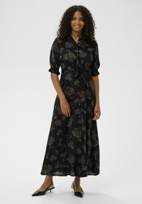 Czarna sukienka maxi w kwiaty z krótkimi bufkami, przewiązanym w talii, z guzikami z przodu i gładką fakturą, zdobiona skomplikowanymi wzorami kwiatowymi.