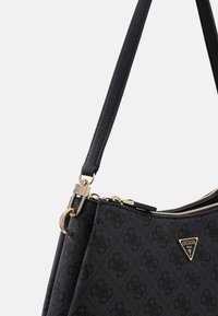 Borsa nera realizzata in materiale testurizzato, con una zip dorata, dettagli metallici e una targhetta con il logo a forma triangolare.