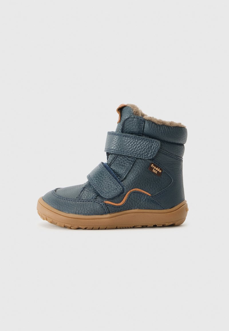 Bottine en cuir bleu avec deux bandes Velcro, semelle en caoutchouc beige et doublure en fourrure en haut. Présente un accent orange incurvé sur le côté.