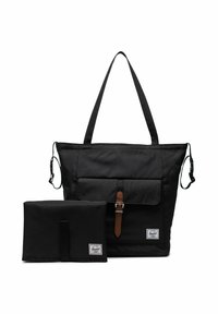 Sac fourre-tout Herschel noir avec poche avant et boucle marron, accompagné d'un matelas à langer pliable noir assorti, les deux exhibant les étiquettes de la marque.