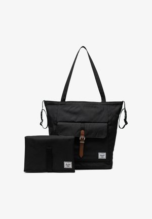 Sac fourre-tout Herschel noir avec poche avant et boucle marron, accompagné d'un matelas à langer pliable noir assorti, les deux exhibant les étiquettes de la marque.