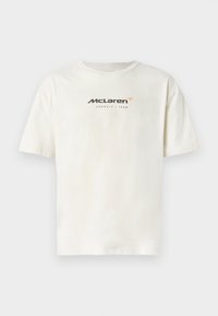 Valge puuvillane T-särk, millel on ümar kaelus ja lühikesed varrukad. Ees on musta ja oranži tekstiga "McLaren Formula 1 Team".