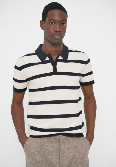 Kötött pólóing tört fehér színben, tengerészkék vízszintes csíkokkal, egyszínű tengerészkék gallérral és rövid ujjal. Texturált anyag és két gombos lezárás.