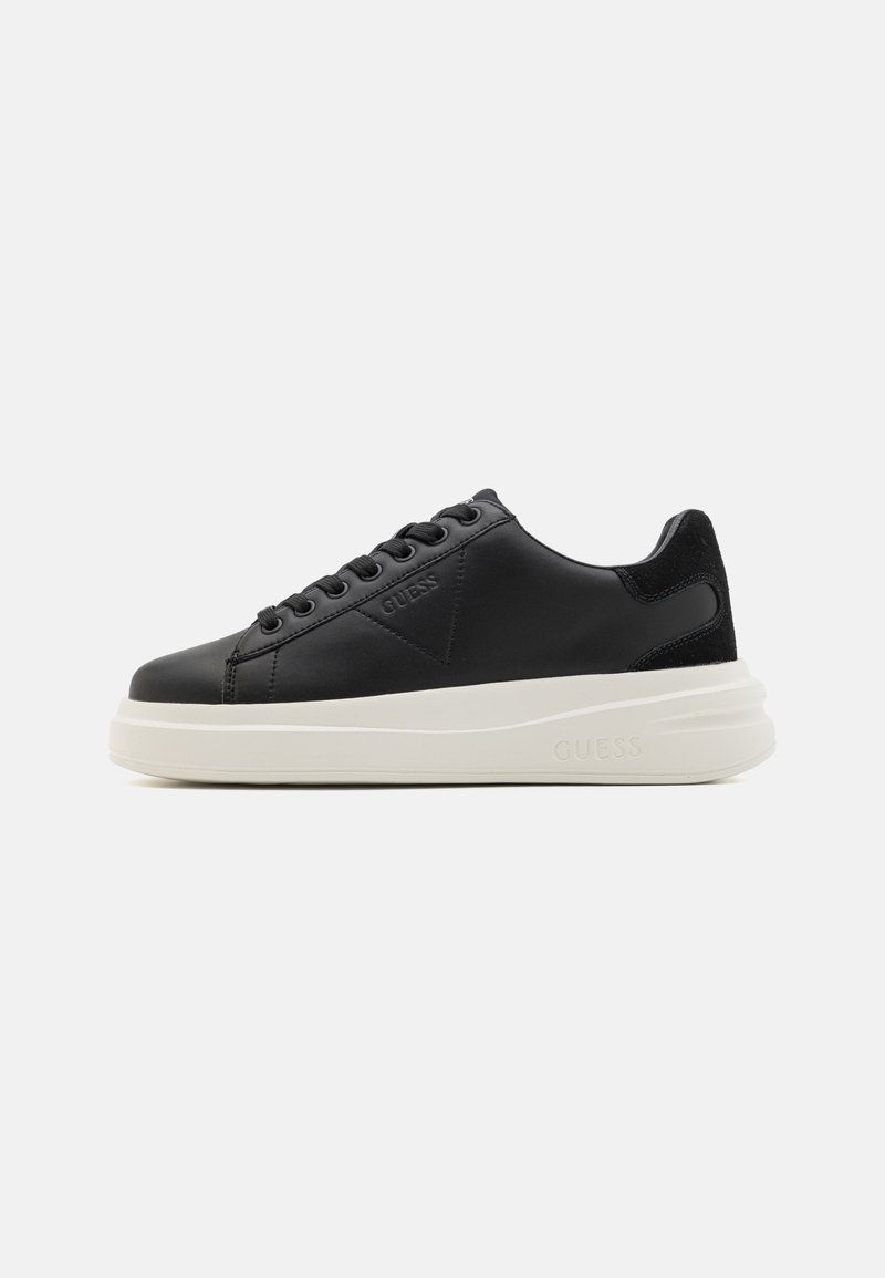 Baskets basses noires avec semelle blanche épaisse, lacets à l'avant et logo « Guess » embossé sur le côté et la semelle.