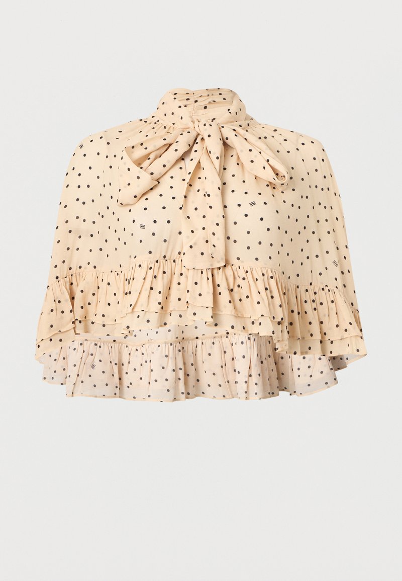 Μπεζ διάφανη μπλούζα με μαύρα πουά, ψηλός λαιμός δεμένος με φιόγκο και στρώσεις βολάν στο τελείωμα.