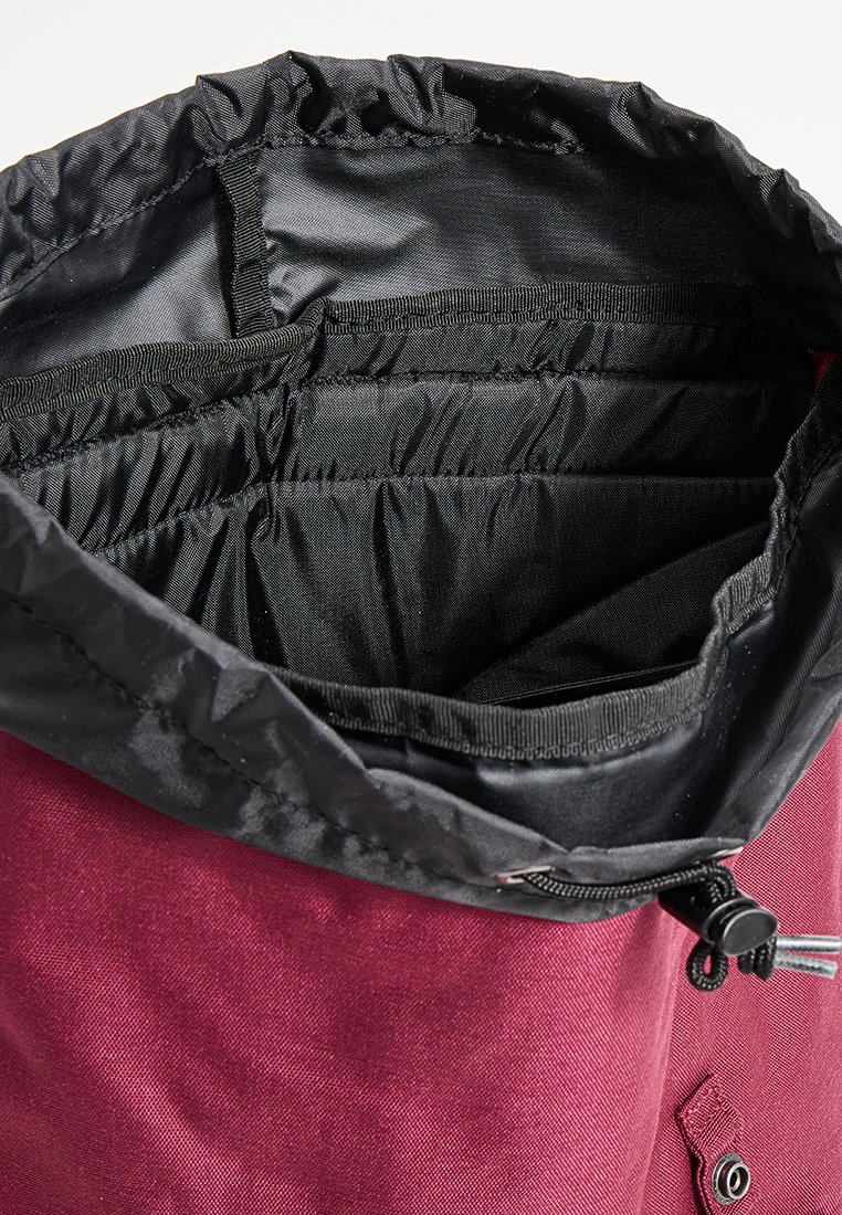 Bordeauxfarbene Stofftasche mit schwarzem Nylon-Innenfutter. Verfügt über einen Kordelzugverschluss und interne Fächer zur Organisation. Robuste Konstruktion.
