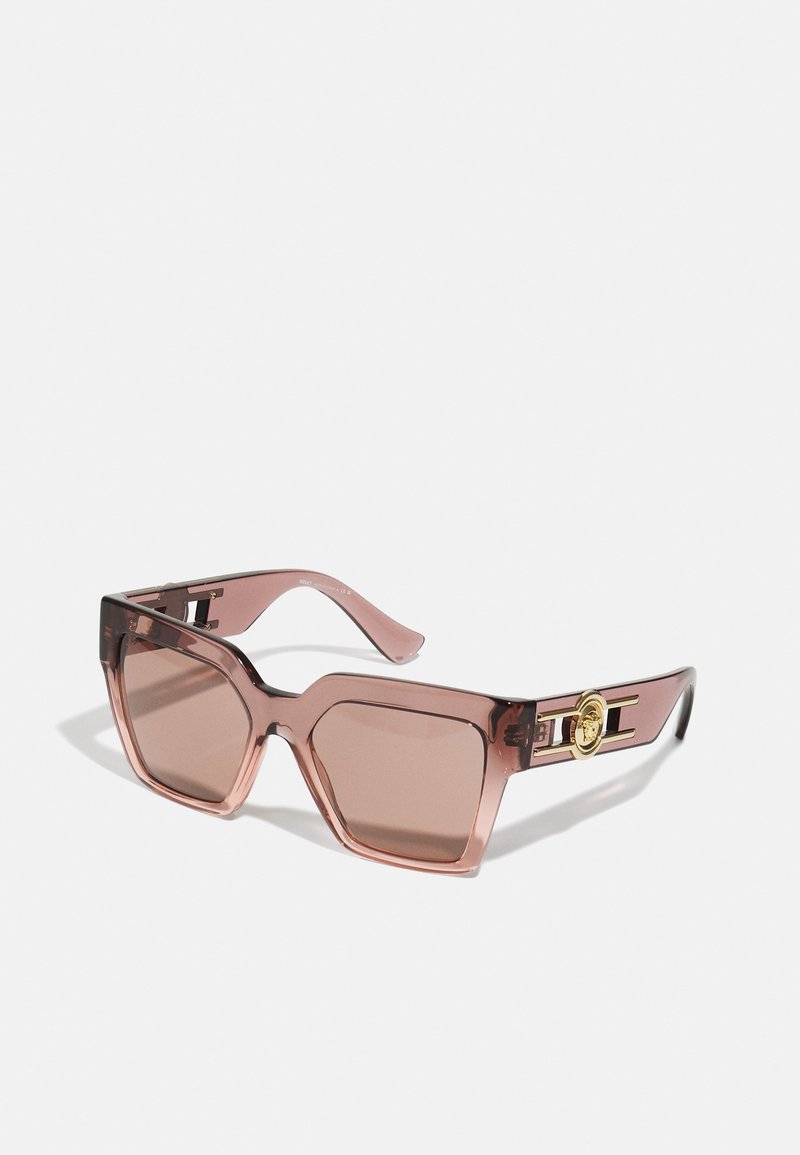 Ochelari de soare pătrați din plastic cu nuanță roz și lentile maro. Prezintă accente de hardware aurii pe benda ochelarilor. Textură netedă pe întreaga suprafață.