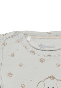 Light gray baby onesie with brown paw prints and a snap closure near the neckline.