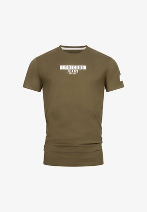 T-shirt verde oliva a maniche corte in cotone. Presenta un logo stampato bianco con la scritta "INDICODE JEANS" e "EST.1993" sul davanti. Design semplice.
