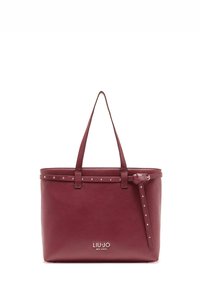 Bolso tote de cuero granate con doble asa, tachuelas a lo largo del borde superior y cierre de cremallera. Presenta el logo "LIU JO MILANO" en el frente.