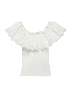 Haut blanc à épaule dénudée avec un volant en dentelle œillet le long de l'encolure, des bords festonnés et un corps en rib ou ajusté.