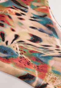 Fürdőruha anyag, amely egy színes, absztrakt mintával rendelkezik, élénk piros, kék és sárga színek keverednek benne csillogó textúrával.