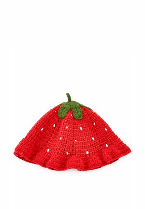 Czerwona szydełkowana czapka w kształcie truskawki z małymi otworami oraz zielonymi listkami i gałązką na górze, ułożona płasko na białym tle.