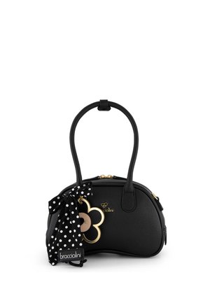 Borsa in pelle nera con due manici, ciondolo a forma di fiore dorato e un nastro a pois bianco e nero legato al manico.