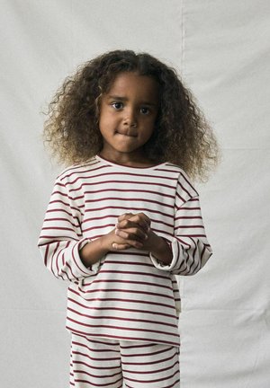 Gestreiftes Loungewear-Set in Creme mit burgunderroten horizontalen Streifen. Das Langarmoberteil hat einen Rundhalsausschnitt und die Hose hat eine lockere Passform.