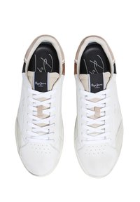 Vita sneakers med en slät läderovandel, beige och bruna suedekanter samt vita snören. Har perforeringar på tån och logotyp på tungan.