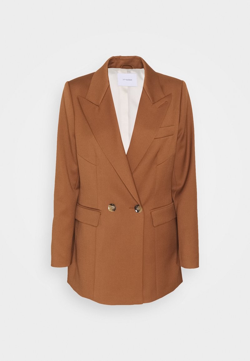 Blazer marron croisé avec larges revers, deux boutons, poches à rabat et doublure intérieure blanche, présenté sur un fond uni.