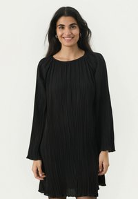 Melnas plisētās kleitas garie piedurknes, apaļš kakls, mīksta auduma tekstūra un slāņveida vienkāršas vertikālas rakstības detaļas.