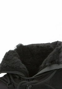 Botas de invierno negras con un forro interior texturizado y suave. Presentan un cierre de cremallera y un sistema de cordones. El material exterior es liso y duradero.