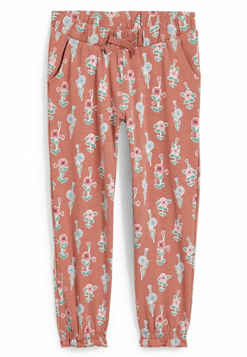 Pantalon pour enfant à taille élastique avec cordon, poches latérales, motif floral rose, bleu et vert sur un fond terracotta atténué.
