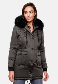 Gevoerde parka met een zwarte nepbont kap, trekkoord in de taille en knopen aan de voorkant. Heeft twee zijzakken en geribbelde boorden. Kleur: donkergroen.