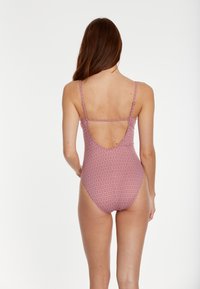 Maillot de bain une pièce avec un motif géométrique en rose et blanc, dos échancré, fines bretelles et tissu extensible et lisse.