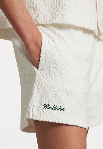 Balti teksturētie šorti ar reljefu, kuru apakšmalā ir izšūts zaļš "Wimbledon" logo un sānu kabata.