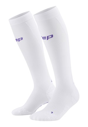 Weiße knielange Socken mit gerippter Textur, verstärktem Fersen- und Zehenbereich und einem lila Logo. Glattes Material, entworfen für Komfort und Unterstützung.
