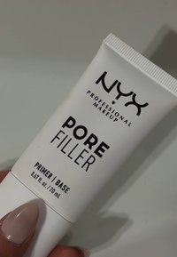 Tube blanc de primer NYX Pore Filler, étiqueté 0,67 fl. oz. avec du texte noir. Présente un capuchon strié et une surface lisse.