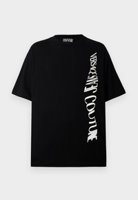 Svart bomull T-skjorte med korte ermer som har hvit skrå tekst "VERSACE JEANS COUTURE" på fronten, rund halsdesign.